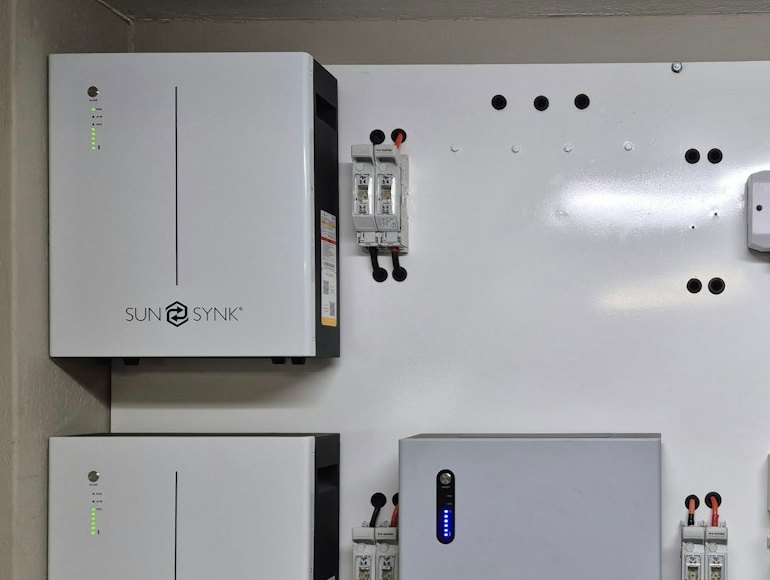 Close-up of wall-mounted home battery modules with DC isolators